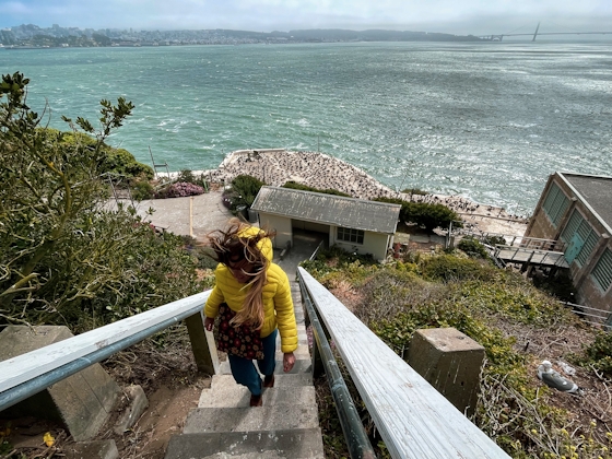 Woman walking up stairs overlooking the Pacific Ocean from Alcatraz Island 