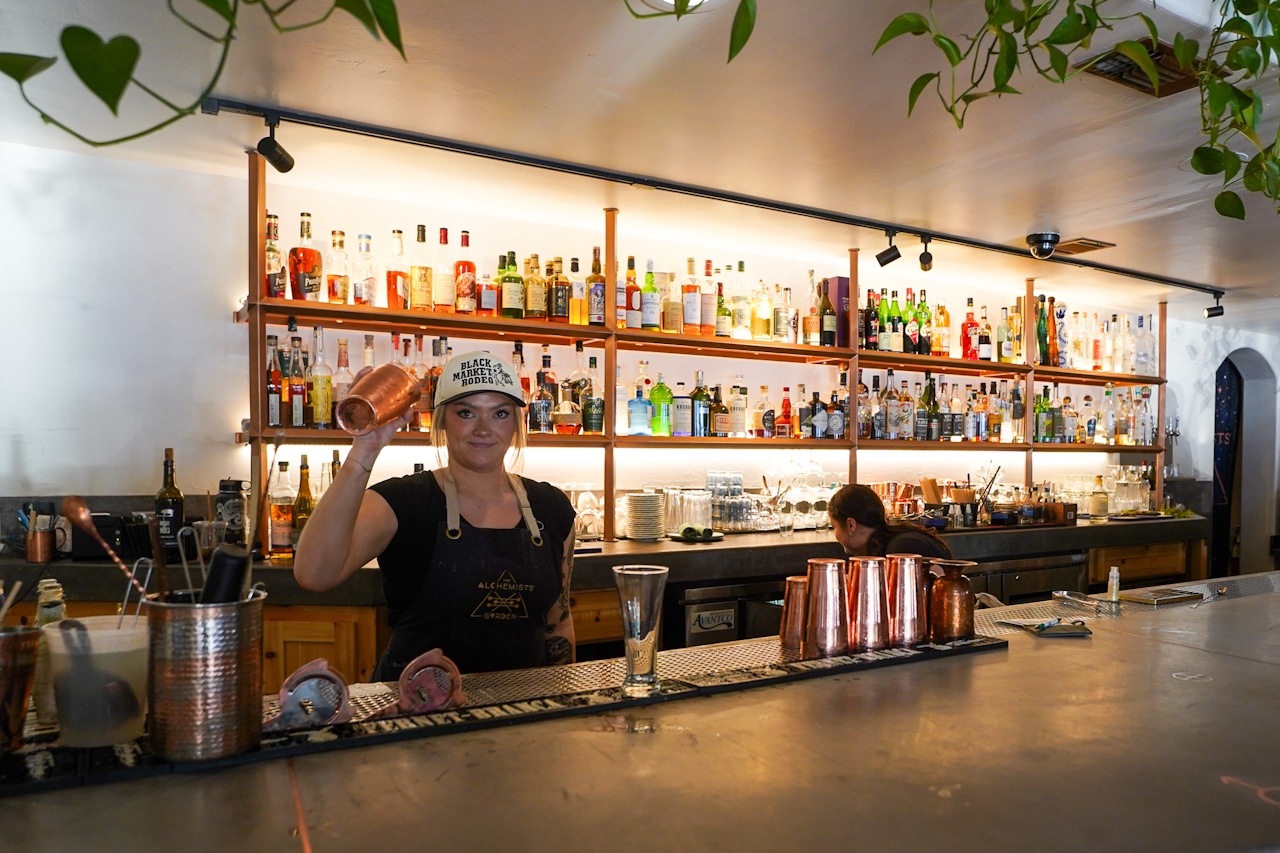 A bartender prepares a drink from behind the bar at the Alchemist's Garden in Paso Robles