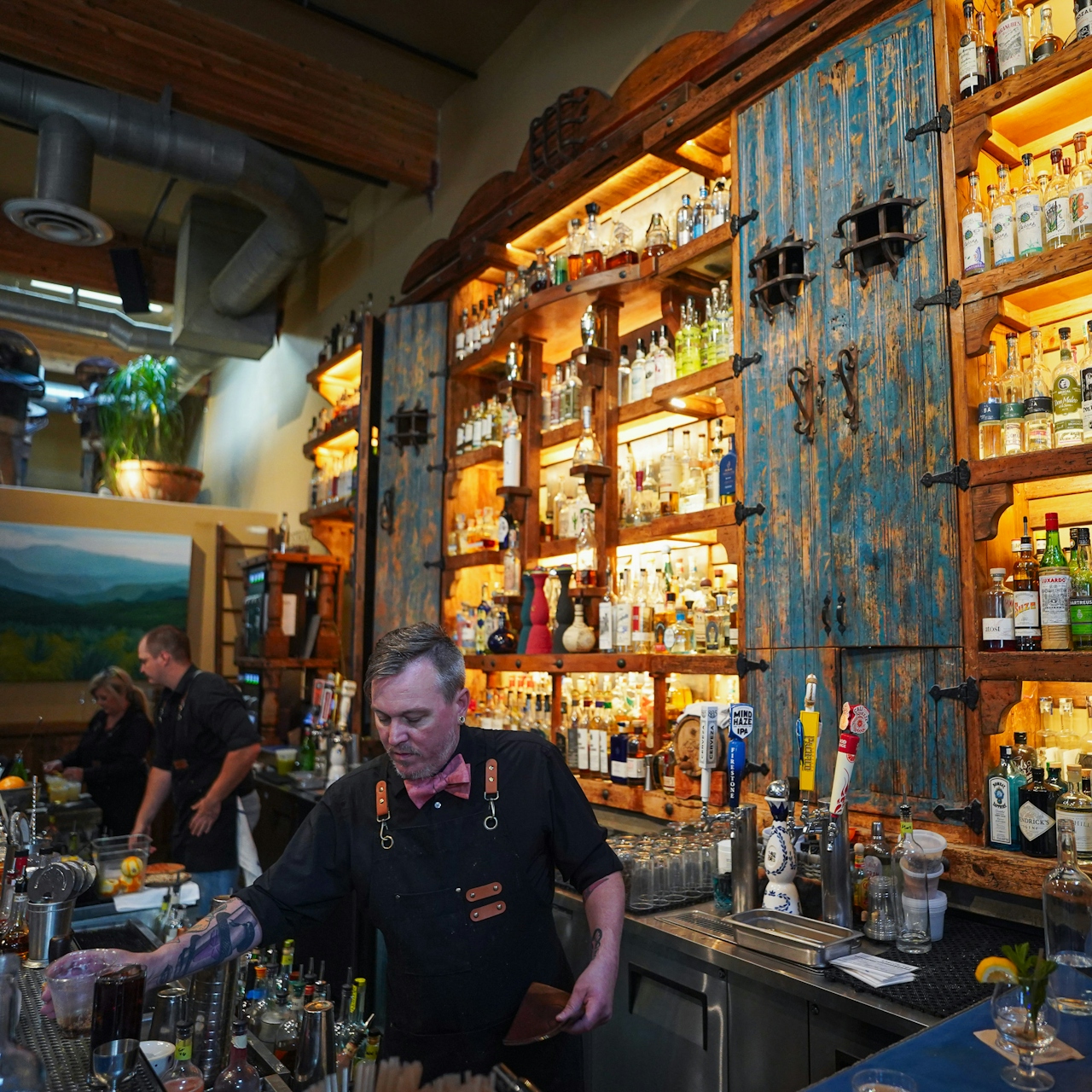 A bartender works behind the bar with a giant wall filled with various tequilas at Fish Gauch in downtown Paso Robles