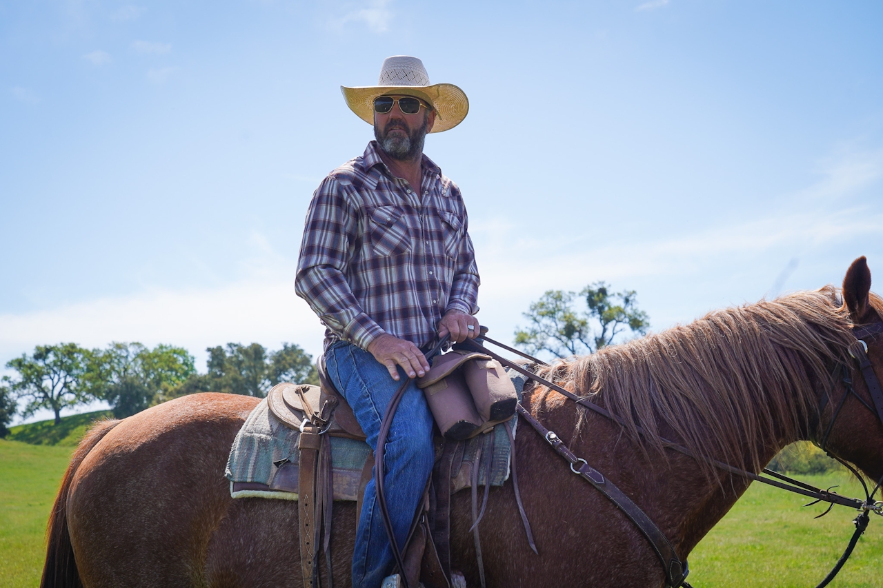 Brian Hallstatt sits on one of his horses as he guides a horseback riding tour with his company Central Coast Trailrides
