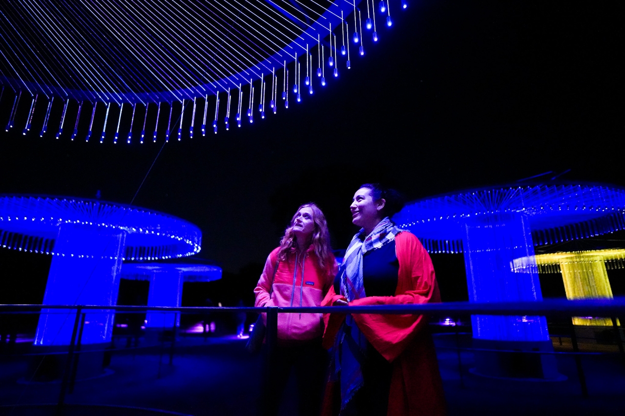Two women looking at the FOSO art and light exhibit at Sensorio 